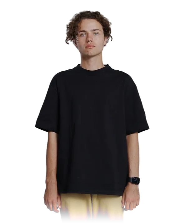 A man in a black heavyweight tee and sand trousers, facing the camera